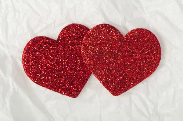 Glanzende rode harten op wit papier — Stockfoto