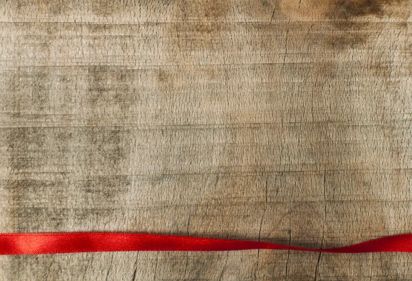 Cinta roja para envoltura de regalo sobre fondo de madera — Foto de Stock