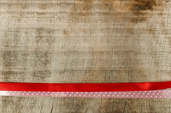 Ruban rouge pour emballage cadeau sur fond en bois — Photo