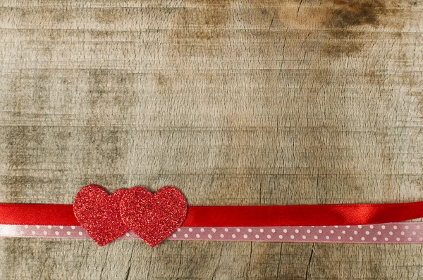 Red ribbon tape and two hearts — Stock Photo, Image