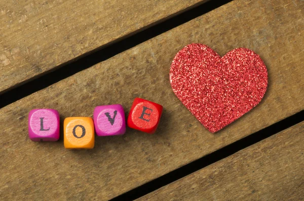 Word love on multicolored wooden cubes on wooden background — Stock Photo, Image