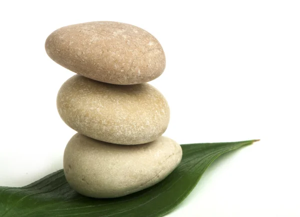 Stacked stones on base of green leafs — Stock Photo, Image
