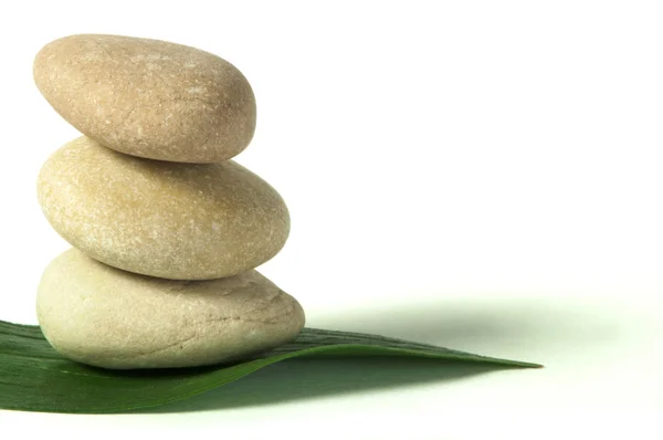 Stacked stones on base of green leafs — Stock Photo, Image