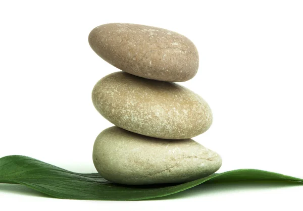 Stacked stones on base of green leafs — Stock Photo, Image