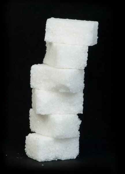 Černé hrudky cukru izolované — Stock fotografie