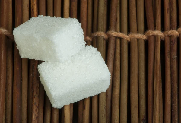 Sugar lumps on wooden base — Stock Photo, Image