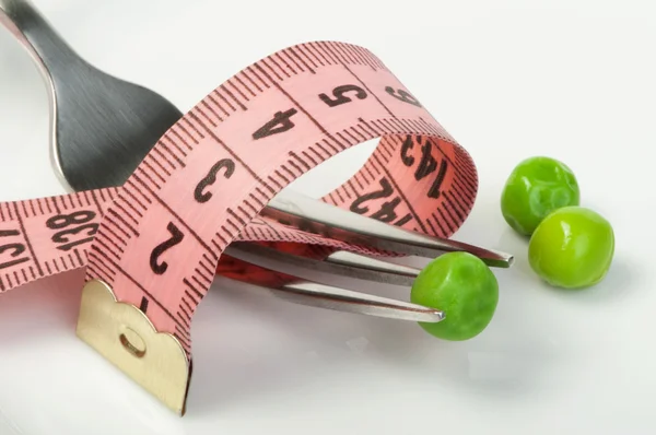 Plate with peas and centimeter measure — Zdjęcie stockowe