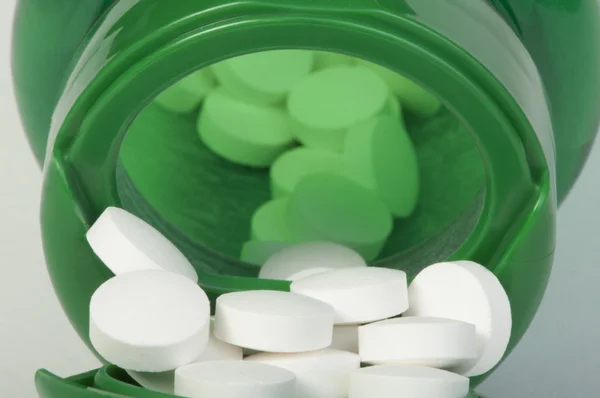 Witte pillen en een container — Stockfoto