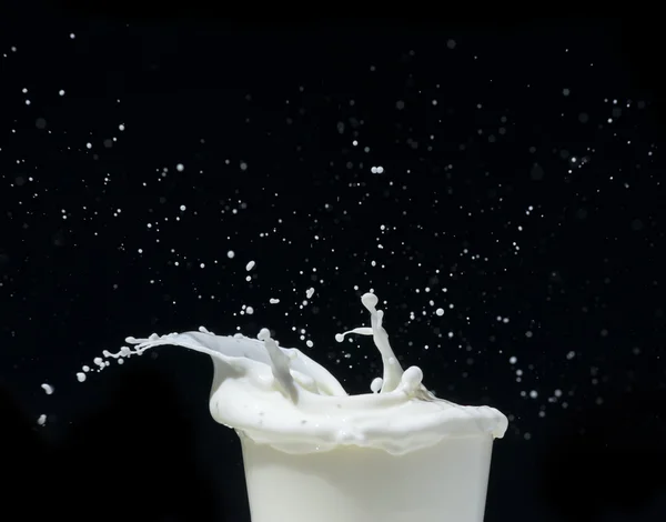 Salpicar leche sobre fondo negro — Foto de Stock