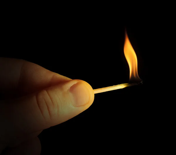 Hand som håller brinnande match stick — Stockfoto