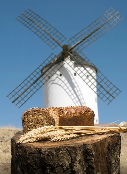 Different breads and windmill in the background — Stock Photo, Image