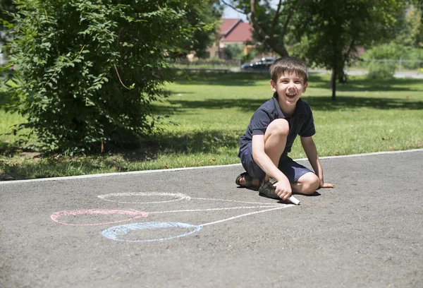 Bambino che disegna palloncini su asfalto — Foto Stock