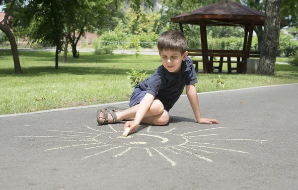 Kind zeichnet auf Asphalt — Stockfoto