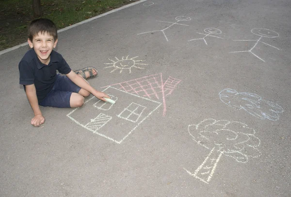 Dítě kreslení slunce a dům na asphal — Stock fotografie
