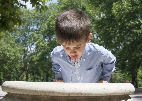 Dítě pitnou vodou z fontány — Stock fotografie