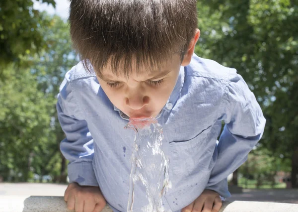Criança água potável de uma fonte — Fotografia de Stock