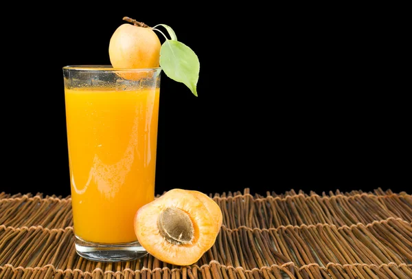 Abrikoos glas sap en fruit zwart geïsoleerd. — Stockfoto