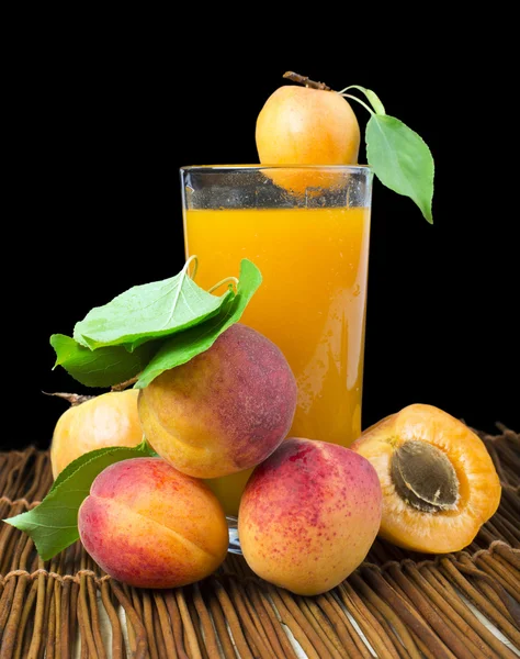 Стеклянный абрикосовый сок и фрукты черный изолированный . — стоковое фото