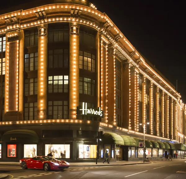 Los grandes almacenes Harrods. Ferrari pasa delante del edificio — Foto de Stock