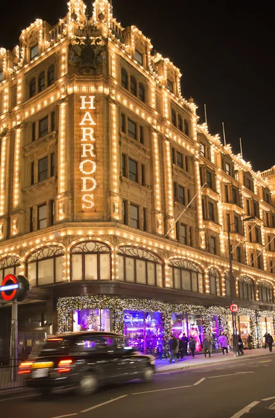 Harrods department store. Taxi passes in front of it — Stock Photo, Image