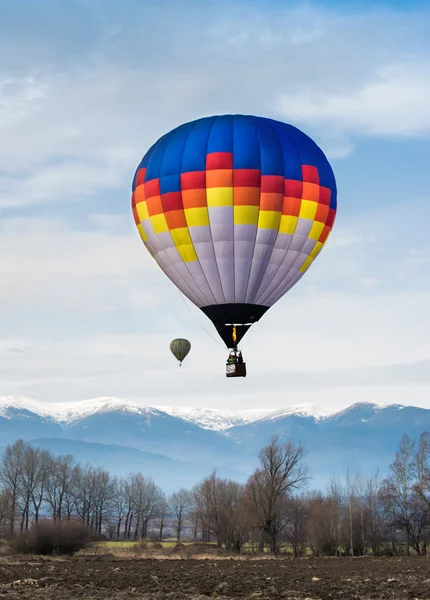 Veelkleurige ballon in de blauwe hemel — Stockfoto