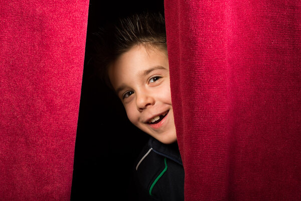 Child appearing beneath the curtain
