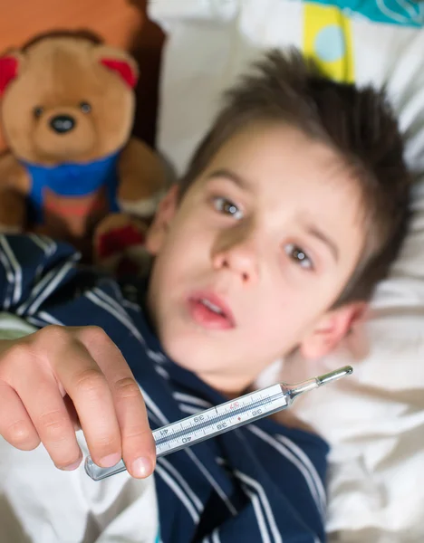 Enfant malade au lit avec ours en peluche — Photo