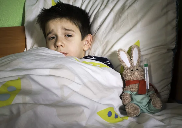 Niño enfermo en la cama con osito de peluche —  Fotos de Stock