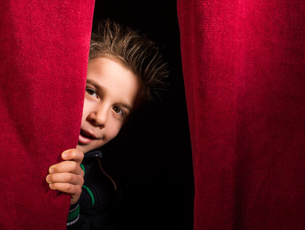 Child appearing beneath the curtain