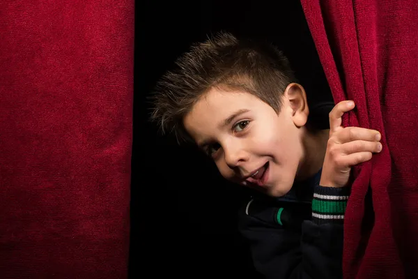Niño que aparece debajo de la cortina — Foto de Stock