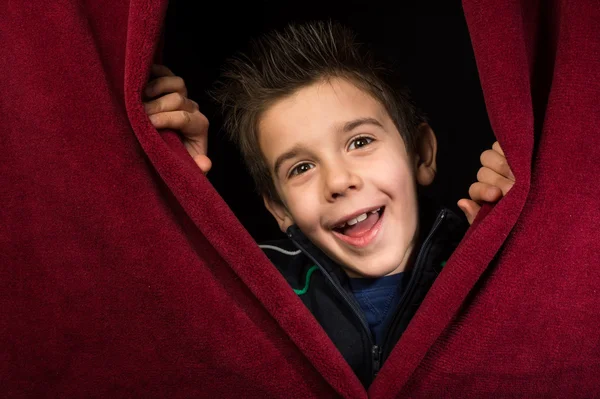 Niño que aparece debajo de la cortina — Foto de Stock