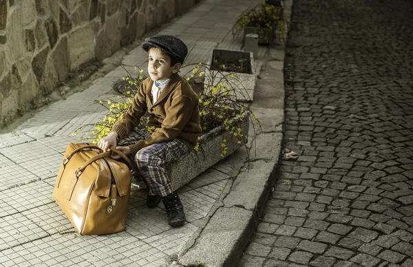 Criança em uma estrada com saco vintage — Fotografia de Stock