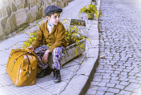 Niño en una carretera con bolso vintage —  Fotos de Stock