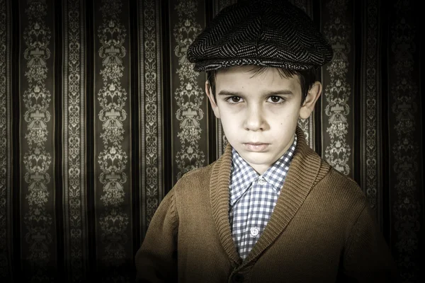 Niño frunciendo el ceño en ropa vintage y sombrero — Foto de Stock