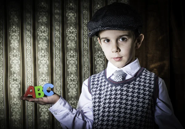 Child in vintage clothes hold letters a b c — Stock Photo, Image