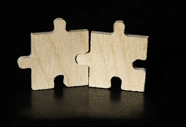 Wooden puzzle on black background — Stock Photo, Image