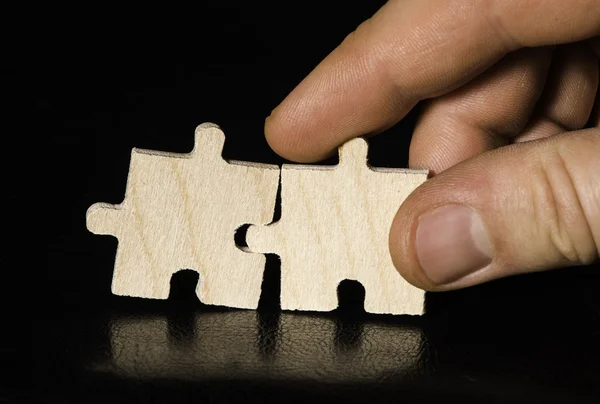 Wooden puzzle on black background. Close up — Stock Photo, Image