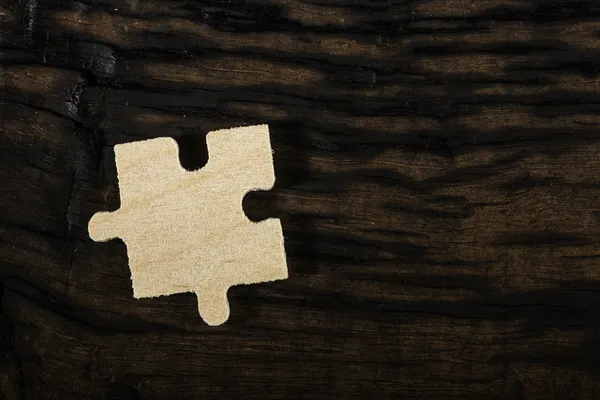 Rompecabezas de madera sobre fondo oscuro . — Foto de Stock