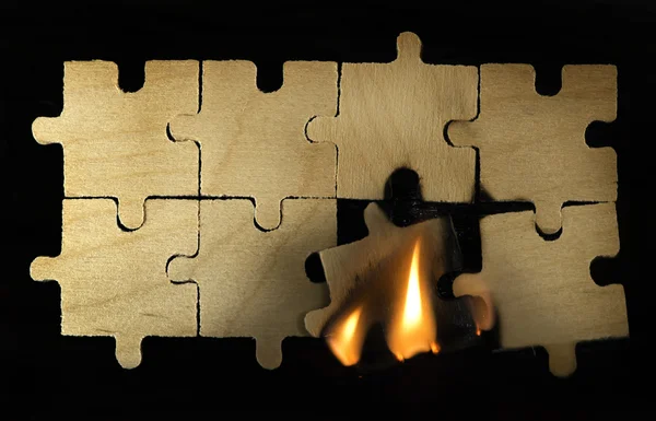Rompecabezas de madera en llamas sobre fondo oscuro . — Foto de Stock