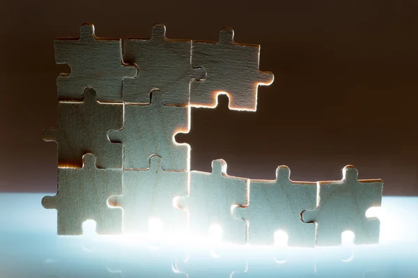 Puzzle in legno e retroilluminazione di sfondo. Da vicino. — Foto Stock