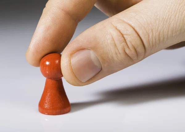 Hand holding red pawn on white background — Stock Photo, Image