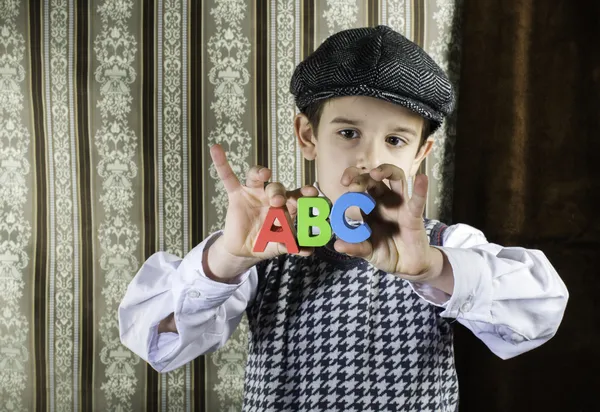 Child in vintage clothes hold letters a b c — Stock Photo, Image