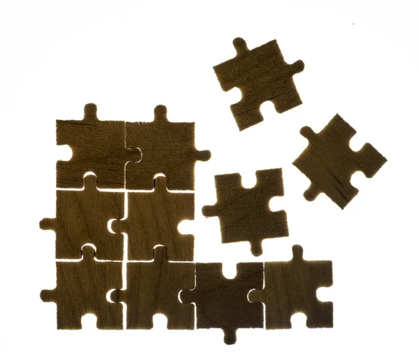 Dřevěné puzzle a podsvícení pozadí — Stock fotografie