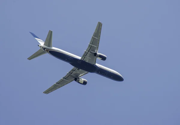 Avião voador no fundo do céu azul — Fotografia de Stock