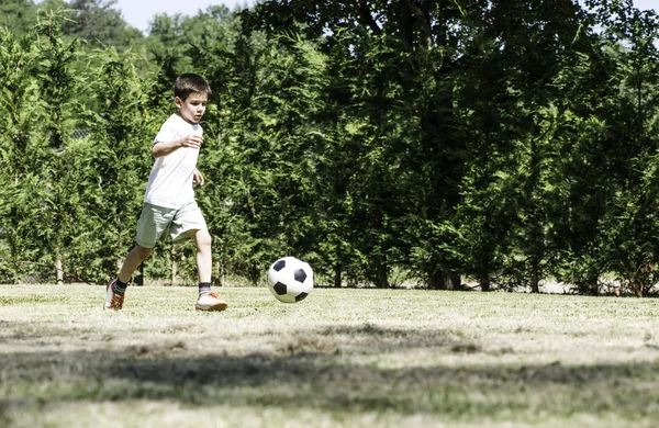 Kind voetballen in een stadion — Stockfoto