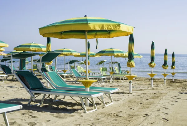 Sonnenliegen und Sonnenschirme am Strand — Stockfoto