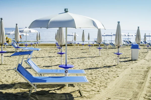 Solstolar och parasoller på stranden — Stockfoto