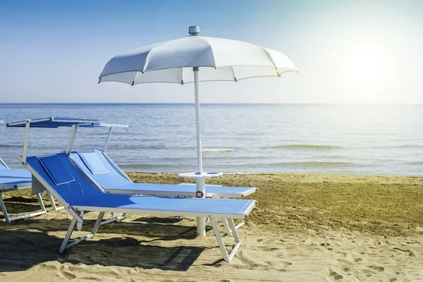 Sonnenliegen und Sonnenschirme am Strand — Stockfoto