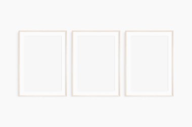 Çerçeve modeli 5x7, 50x70, A4, A3, A2, A1. Üç tane ince, hafif ahşap çerçeve. Galeri duvarı maketi, 3 kare seti. Temiz, modern, minimalist, parlak. Portre. Dikey. Passepartout / mat açılışı 2: 3 çerçeve oranı.