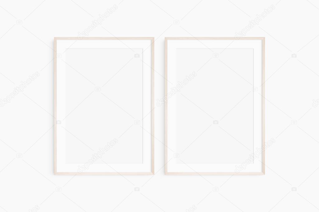 Frame mockup 5x7, 50x70, A4, A3, A2, A1. Set of two thin light wood frames. Gallery wall mockup, set of 2 frames. Clean, modern, minimalist, bright. Portrait. Vertical. Passepartout/mat opening in 2:3 aspect ratio.